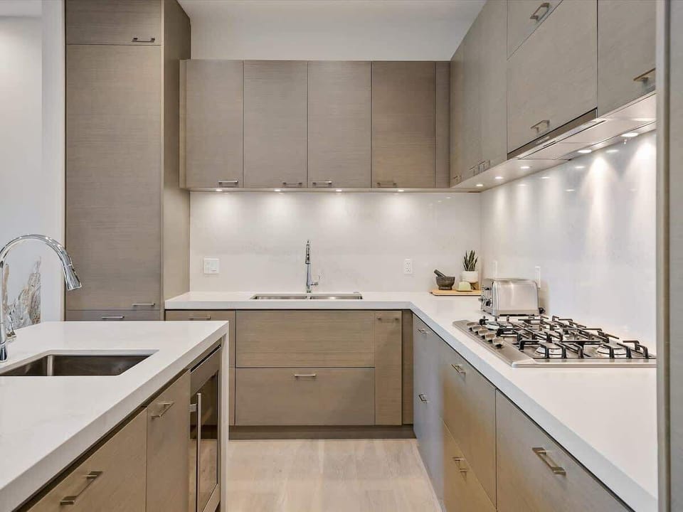 - Modern kitchen with wood cabinetry and sleek quartz countertops  
- Fully equipped space for cooking and entertaining with ease  
- Warm lighting and clean design bring comfort to every meal  
