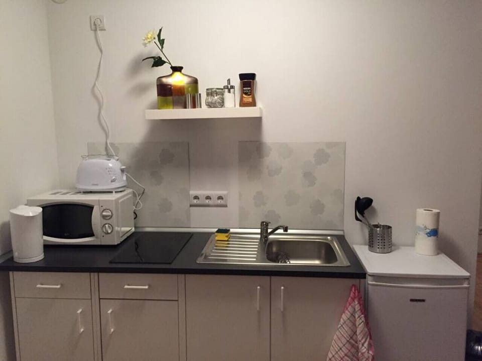 Küchenzeile mit Toaster, Mikrowelle, Wasserkocher und Kaffeemaschine