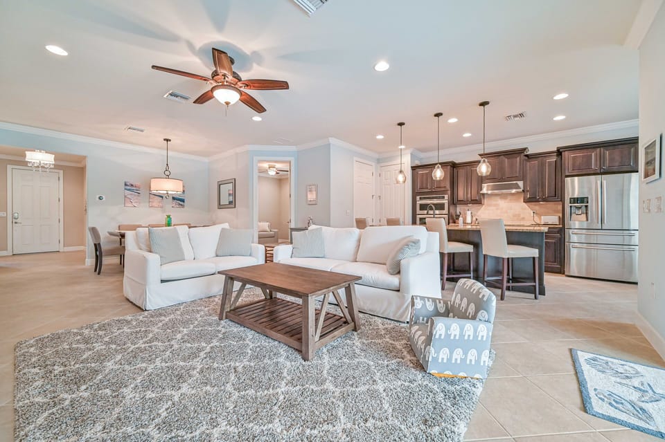 Villa Paradise at The Preserve - Living with 65" smart TV and sliding doors opening up to the screened in pool area