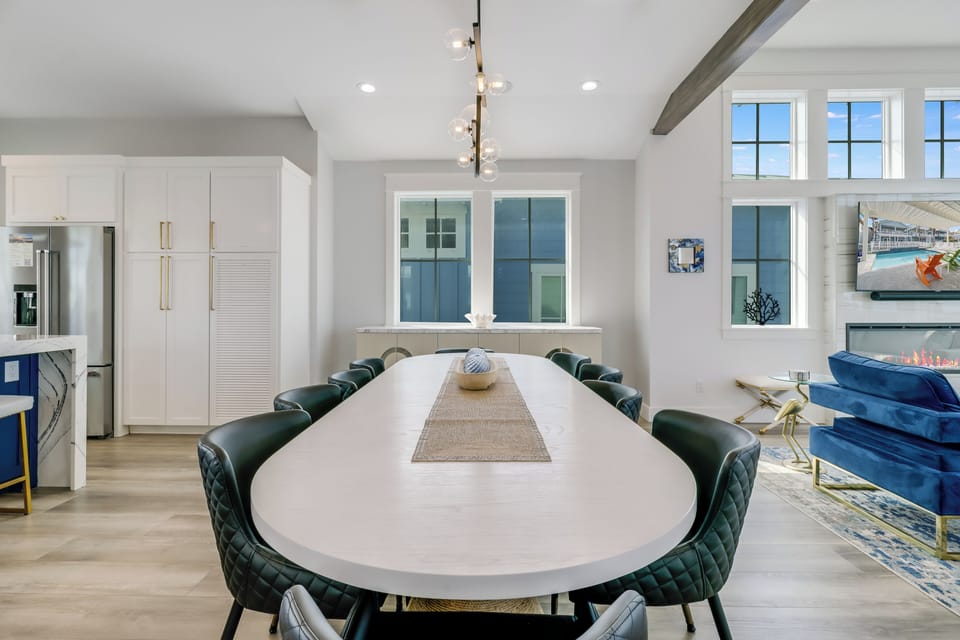 Gather around your elegant dining table where memorable meals and conversations unfold beneath stylish pendant lighting in this sophisticated space.