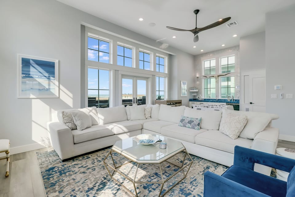Sink into this bright living room with plush sectional seating and stunning natural light streaming through expansive windows.