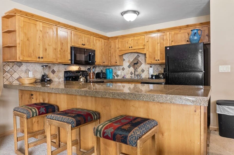 The spacious kitchen bar connects the fully equipped kitchen to the living room/dining area so you can easily stay connected from any room in the shared living space.