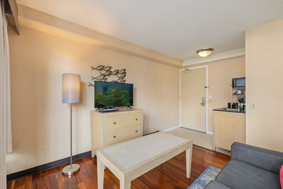 Settle into your bright and welcoming living space, complete with warm wood floors, a flatscreen TV, and a convenient kitchenette for easy snacking and coffee breaks.