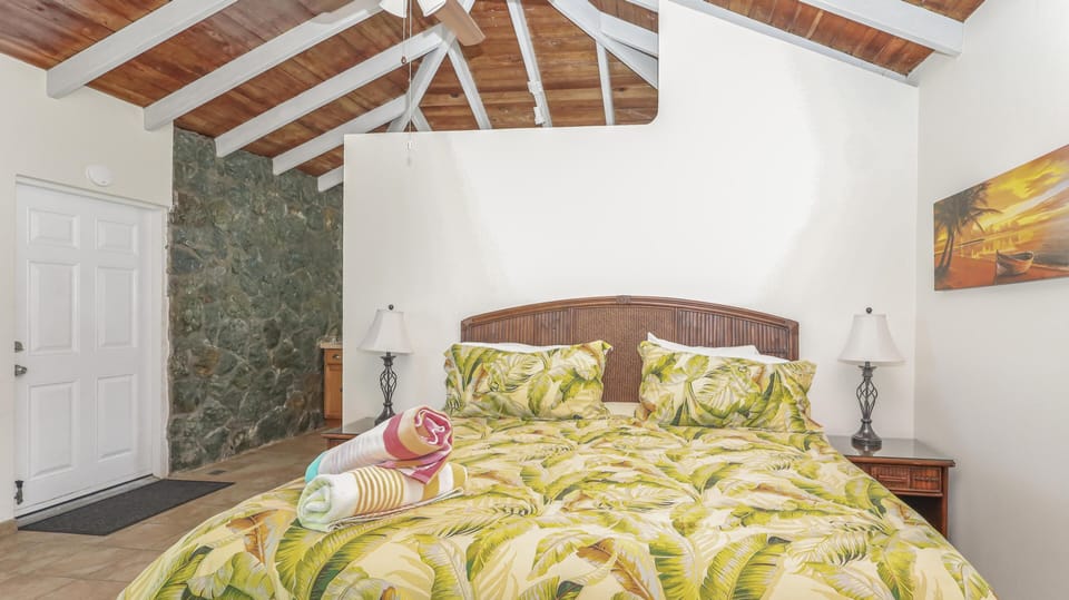 Tiled floor leads to a white entry door beside a textured stone accent wall in the bedroom.