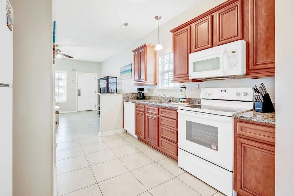 Full kitchen with wood cabinets and white appliances