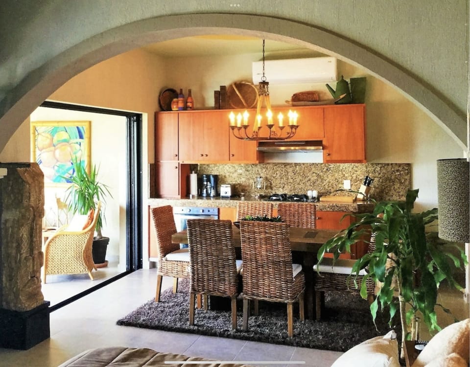 A large dining table is in the full kitchen.