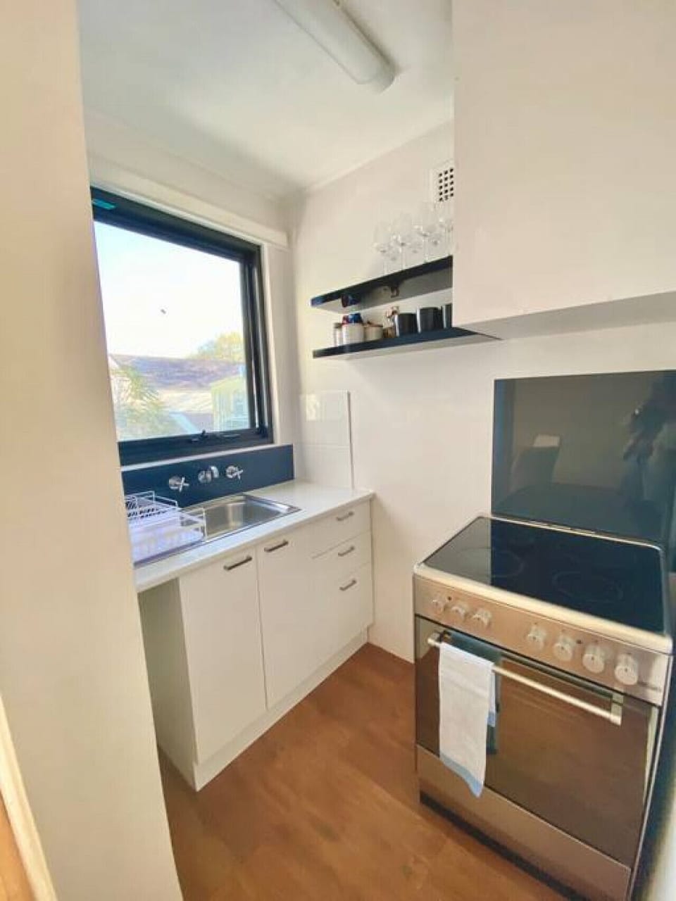 Modern kitchen with electric cooktop, oven and window view