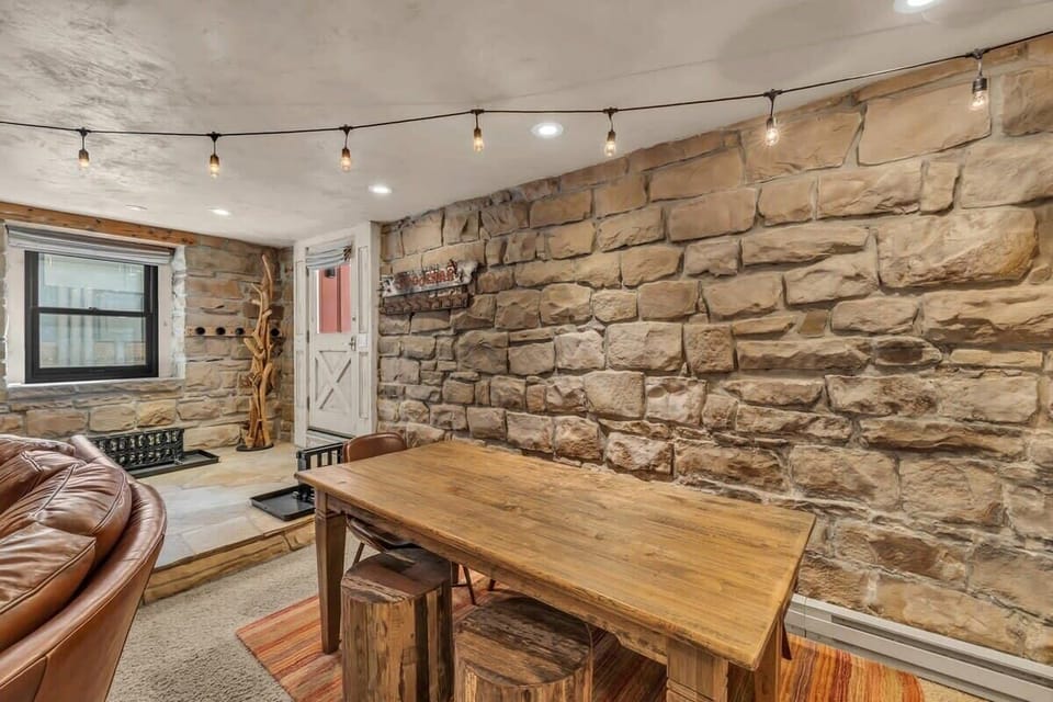 The dining table is situated next to the couch and provides seating for 6.