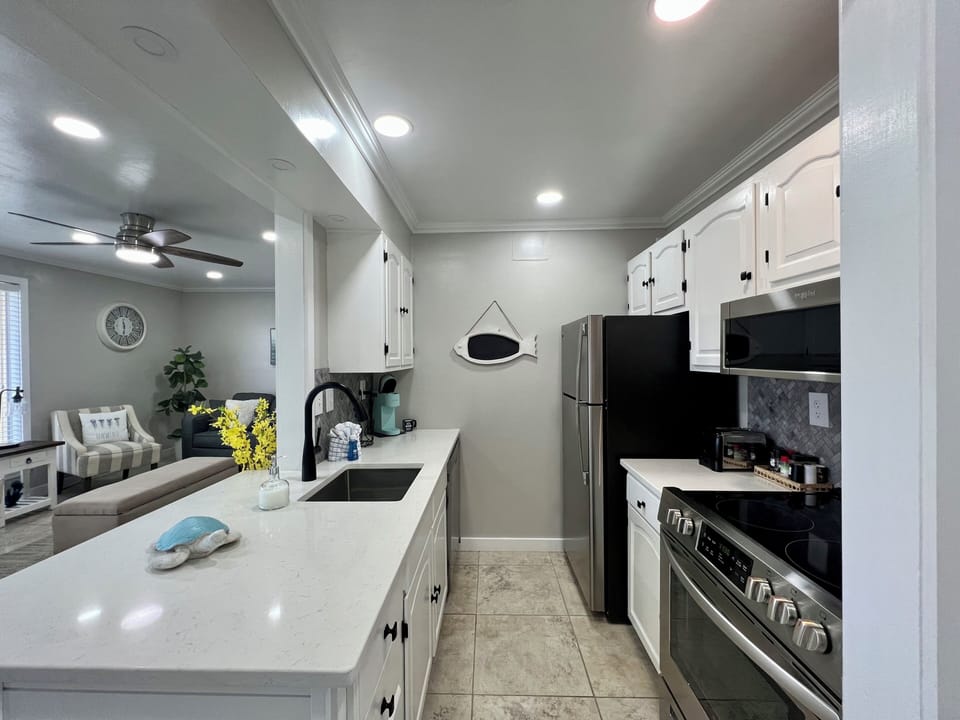Your fully equipped kitchen awaits with modern appliances, granite countertops, and coastal touches—perfect for preparing meals during your stay.