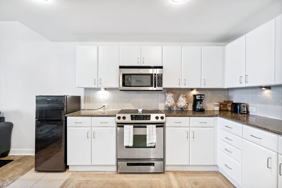 Modern kitchen with stainless steel appliances and ample white cabinetry.