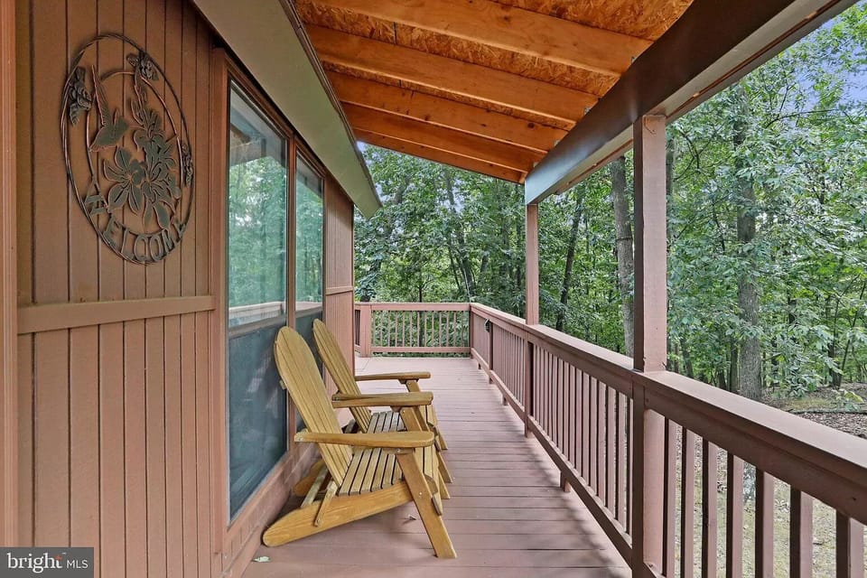 "Unwinding in style: Adirondack chairs on the charming side porch of bliss."