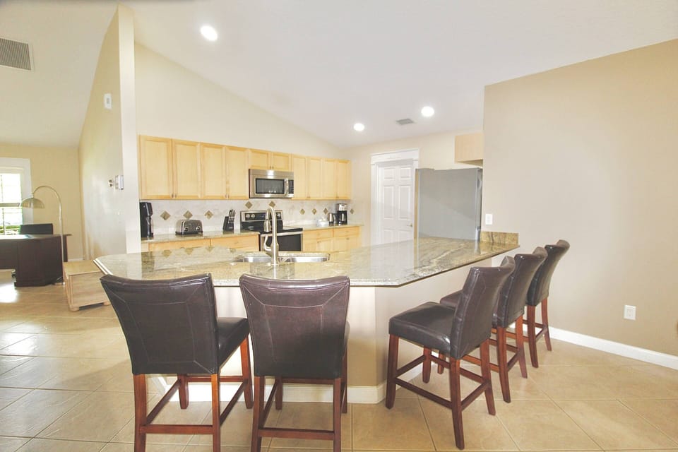 The kitchen has a large granite top island, with leather bar seating for 5.