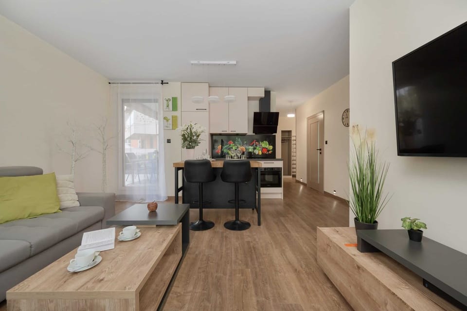 Another angle of the living room, showing the sofa, a wall-mounted TV, and stylish accessories.