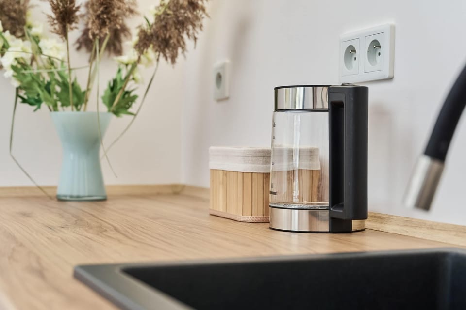 A decorative countertop with natural accents, including dried flowers and modern kitchen appliances. 