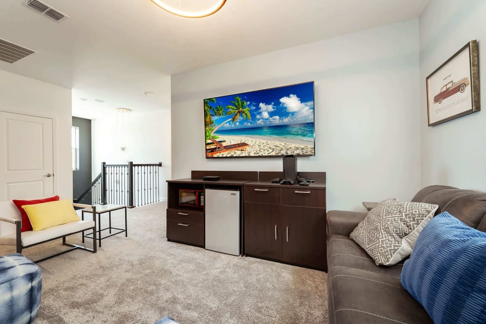 Relax in this cozy living area with a large TV, mini fridge, and comfortable seating, perfect for unwinding after a day of exploring.