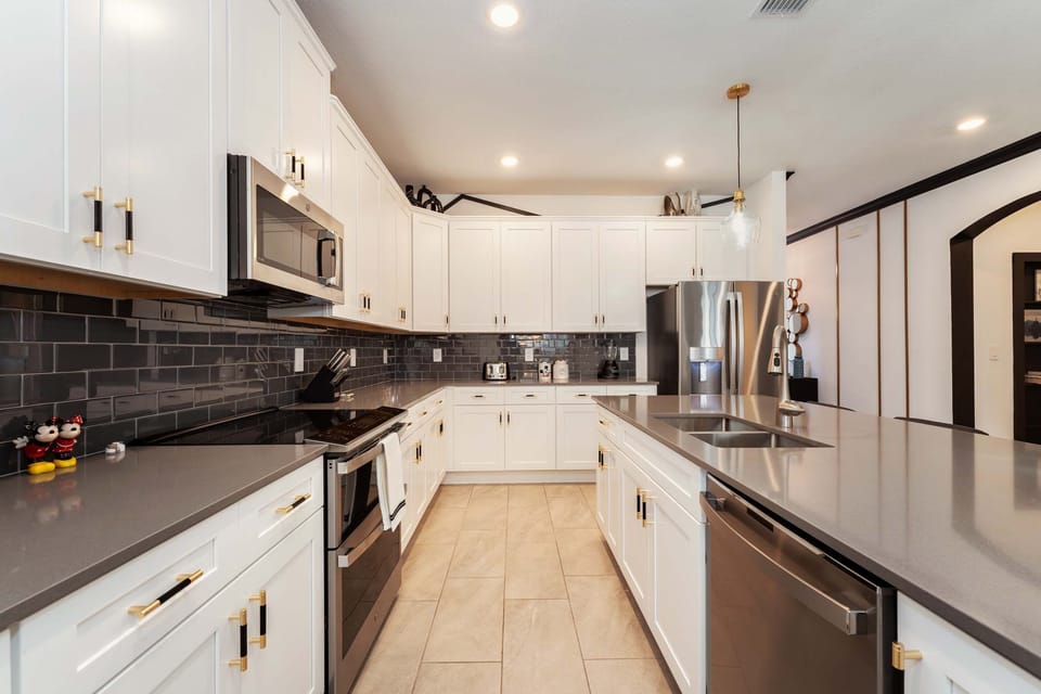Spacious modern kitchen with sleek appliances and ample counter space, perfect for cooking and entertaining.