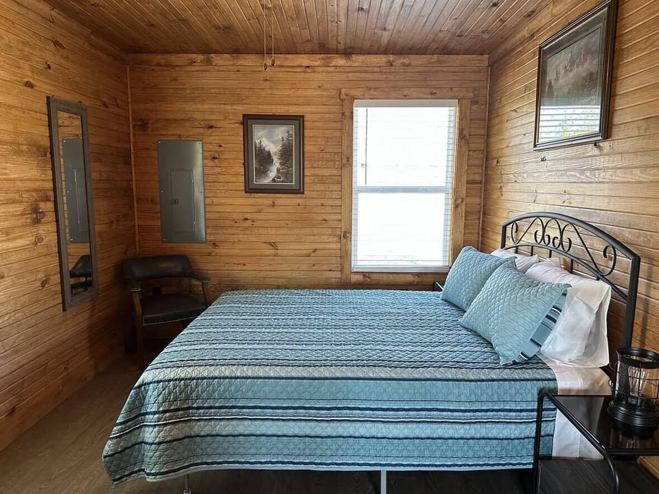 Main floor bedroom features a 40" TV, queen bed, and an electric fireplace.