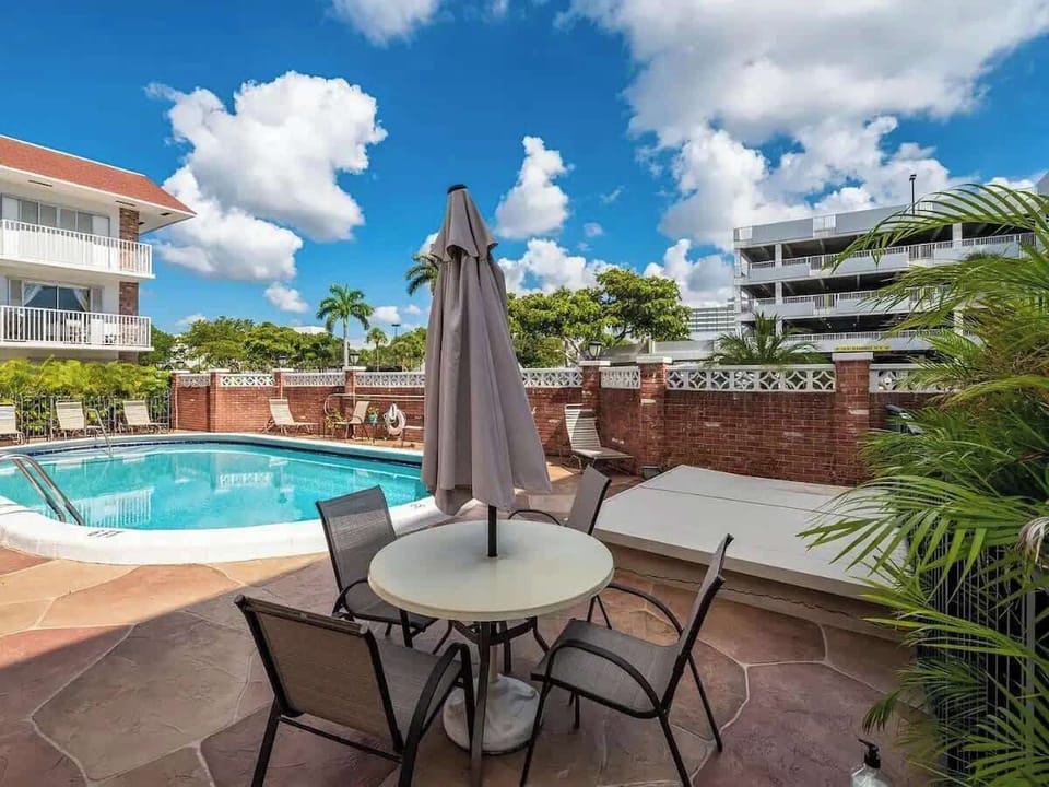 Shared outdoor area with a pool, BBQ, dining tables, and ample seating areas.