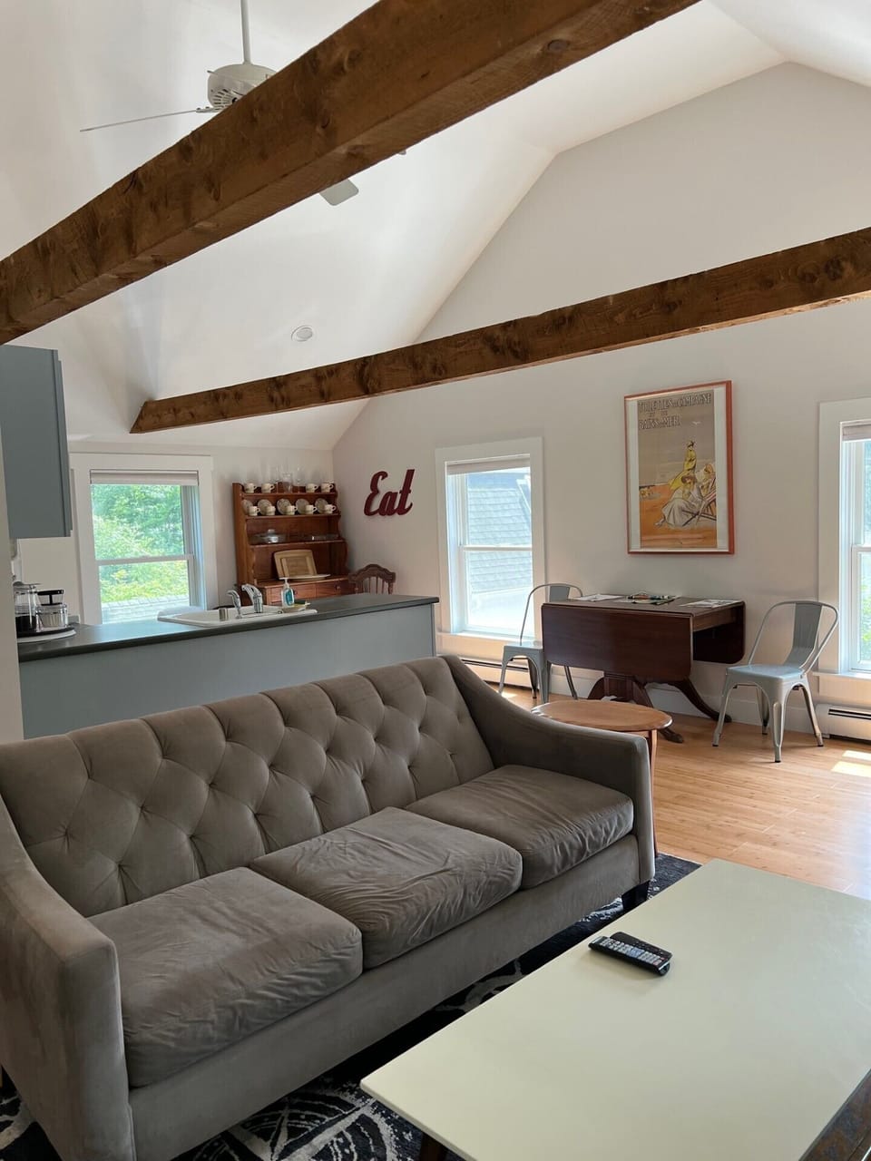 Open living room/dining/kitchen area with hardwood floors and vaulted ceilings.
