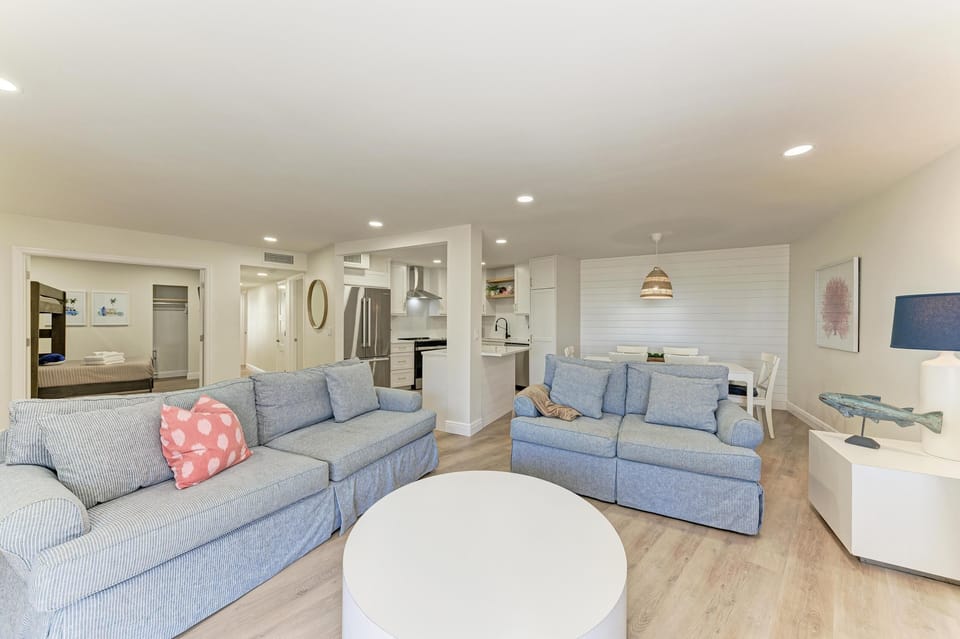 Spacious living room with 2 sofas positioned around a round coffee table