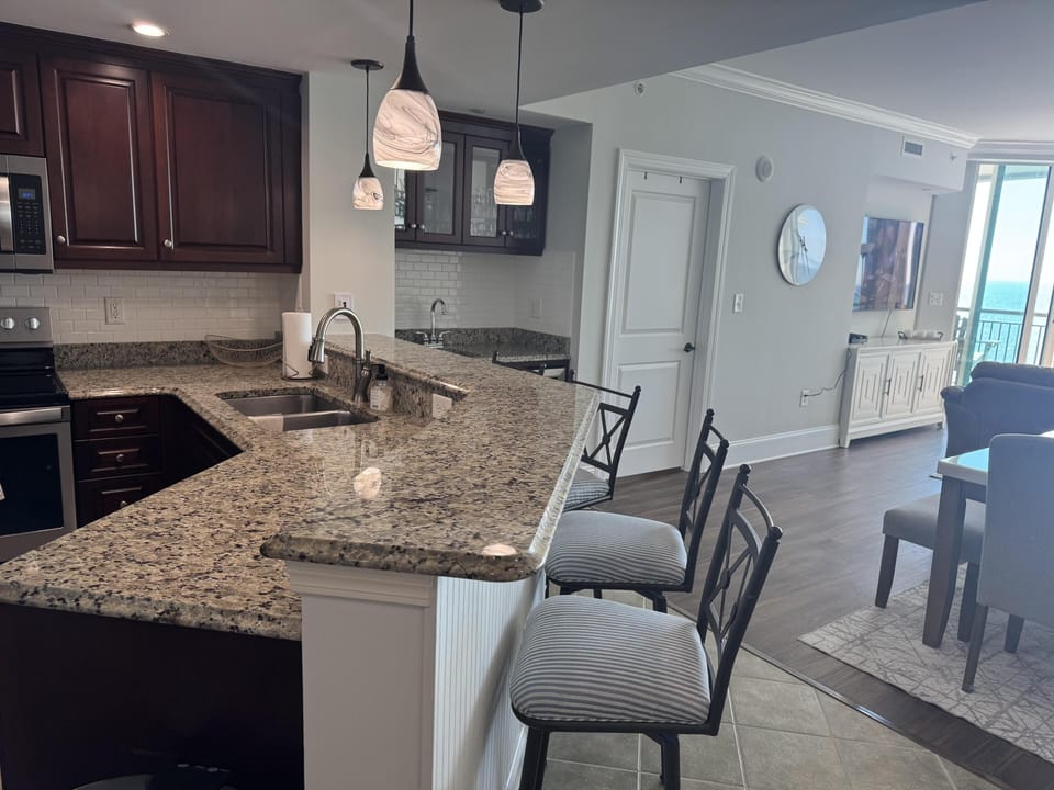 Spacious kitchen and dining area with granite countertops and natural light