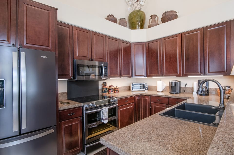 Large fully stocked kitchen with granite counter tops.