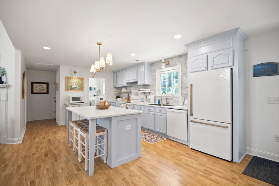 Fully-stocked kitchen with microwave, oven, refrigerator, freezer, + dishwasher.