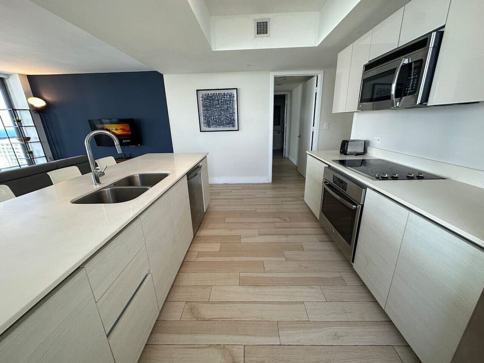Fully equipped kitchen with stainless steel appliances and a stylish backsplash.