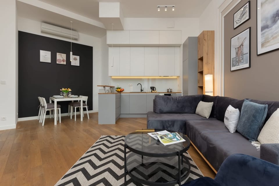 The living area features a sleek coffee table and a flat-screen television.