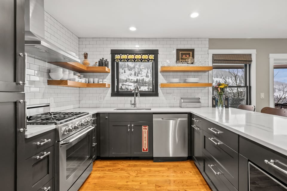 - Modern kitchen with stainless appliances and wood shelves  
- Large island with seating for family and friends to gather  
- Scenic mountain views framed by bright kitchen windows