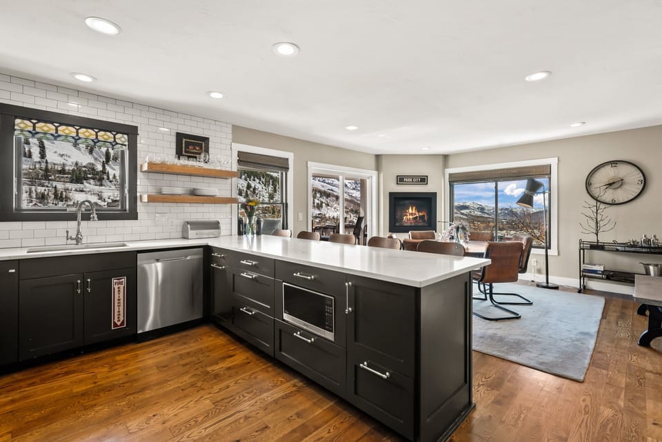 - Open kitchen with bar seating and mountain views  
- Spacious layout flows into dining and living areas  
- Fireplace adds warmth to this modern gathering space