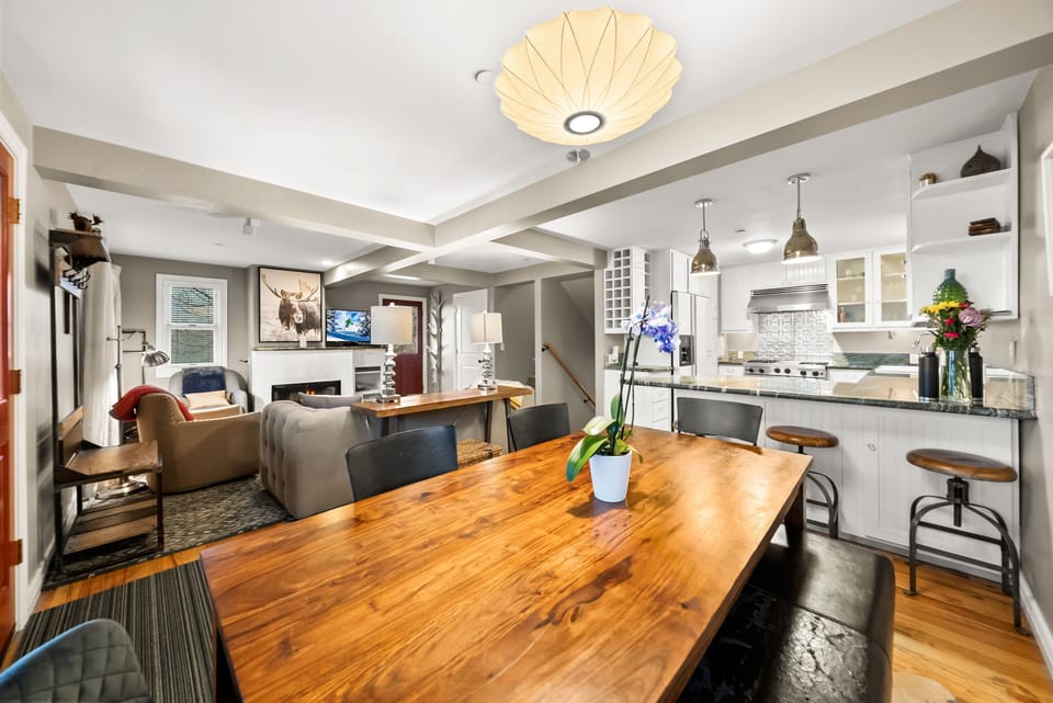 - Dining area with large wood table and seating  
- Open layout connects kitchen and living room  
- Perfect for family meals and group gatherings