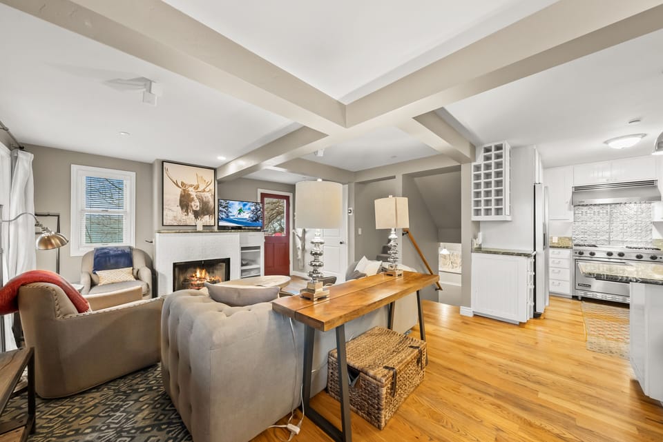 - Cozy living room with fireplace and smart TV  
- Stylish decor and open layout leading to kitchen  
- Perfect for relaxing after mountain adventures