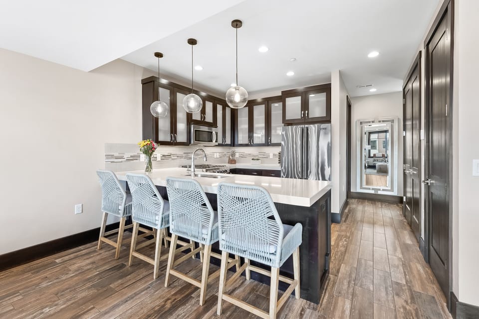- Bright kitchen with large island and seating for four guests  
- Pendant lighting and wooden floors create a warm atmosphere  
- Fully equipped for family meals and entertaining