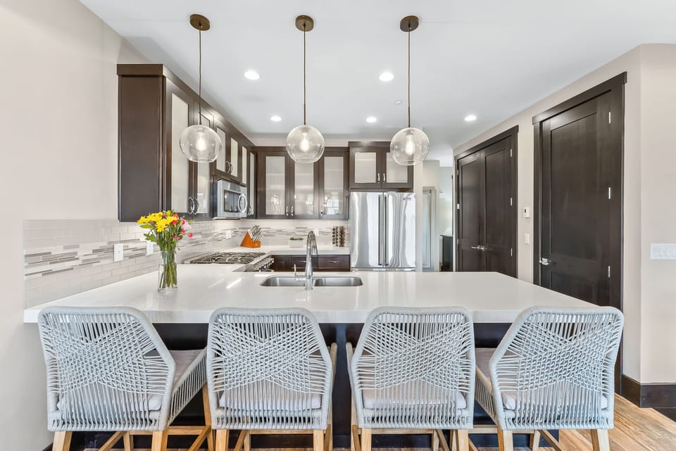 - Sleek kitchen with quartz countertops and stainless appliances  
- Large island with seating for four under pendant lighting  
- Perfect for cooking meals and enjoying modern vacation amenities