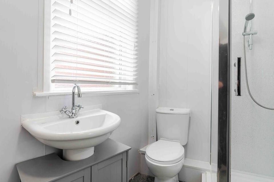 The en suite bathroom connected to Bedroom 1 has a sink, toilet, and shower.