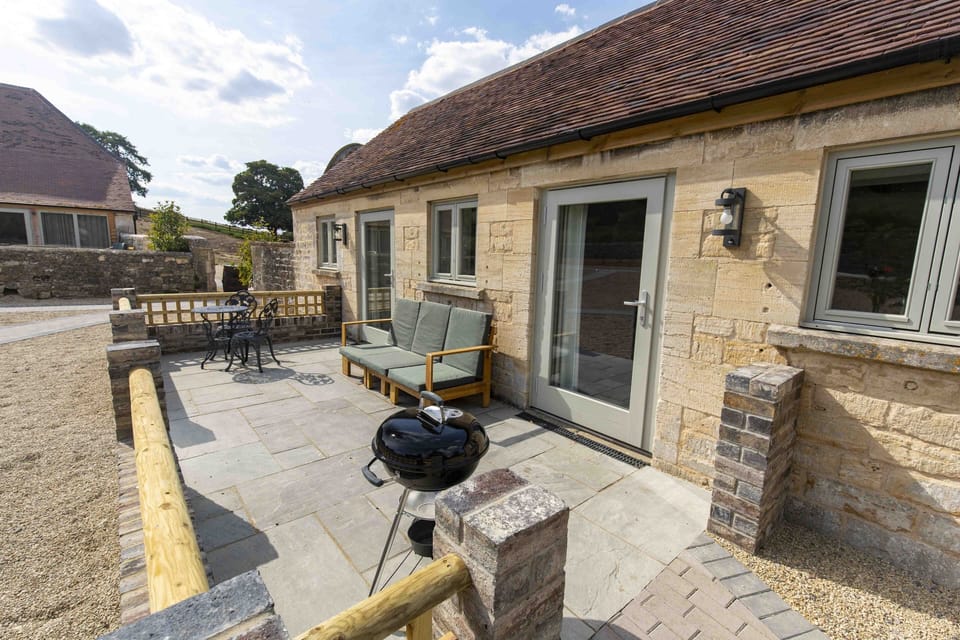Patio with bistro table and chairs, sofa and charcoal BBQ