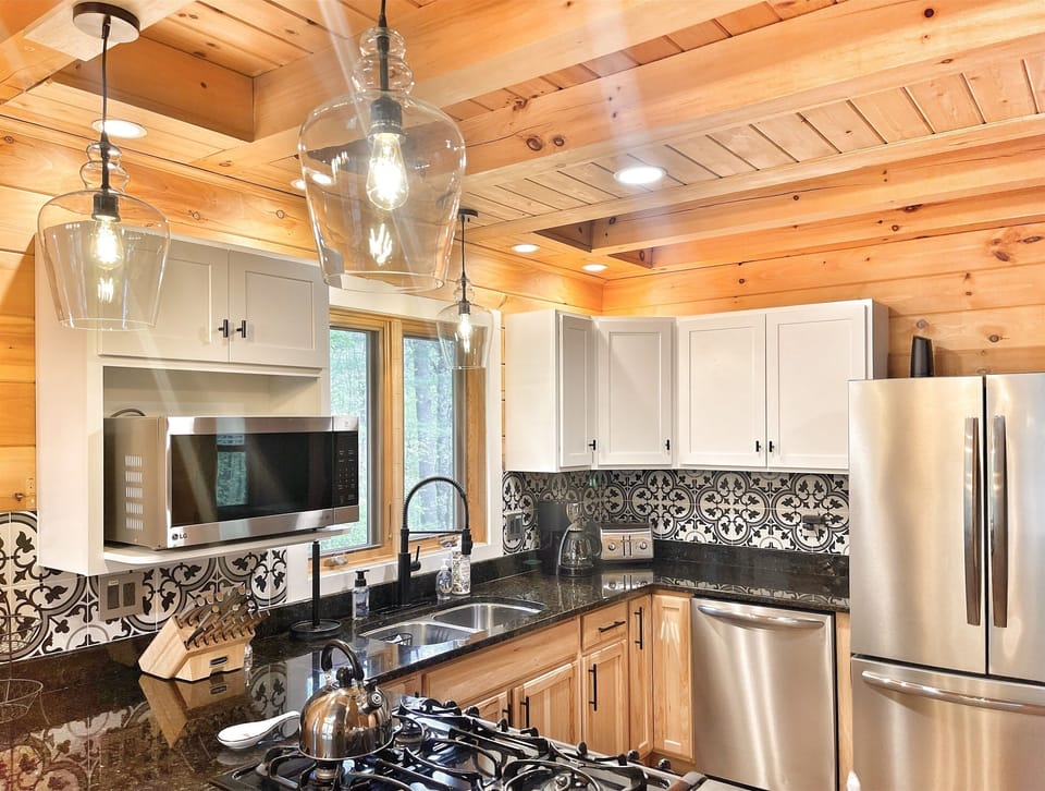 Elegant pendant lighting and wood paneling offers ambiance in the kitchen.