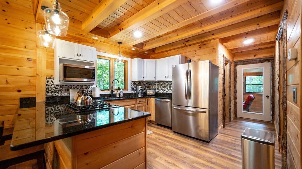 Kitchen appliances include large stainless fridge, dishwasher, microwave, gas stove, coffee maker, and toaster oven.