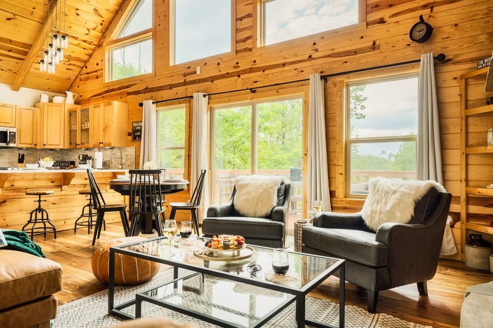 The open-concept living space is filled with natural light with a wall of windows. Access the balcony and outdoor living space from this room.
