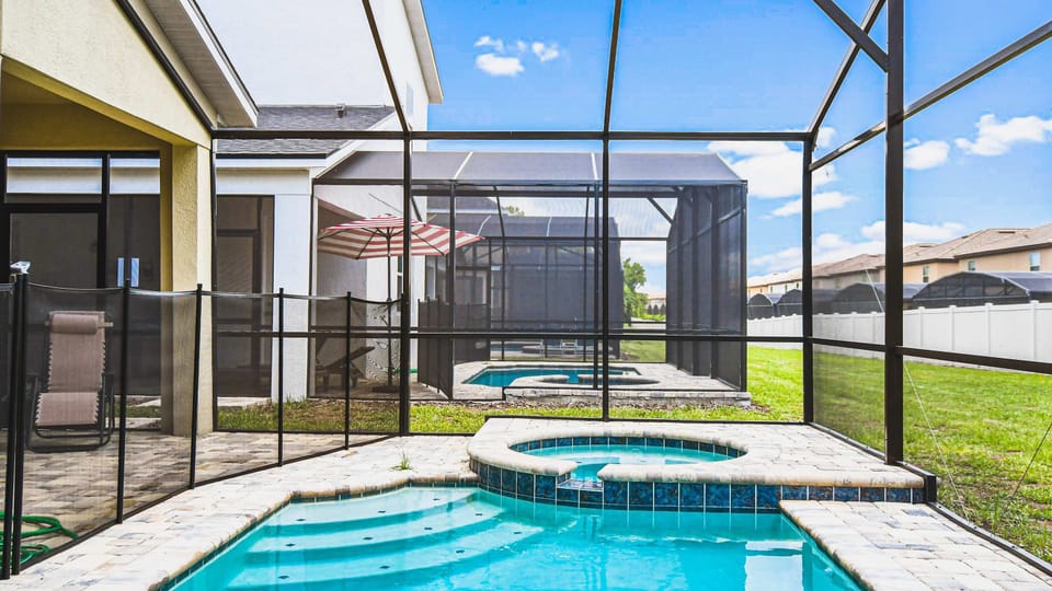 Private screened pool and spa with sunny deck, loungers, and peaceful backyard views.