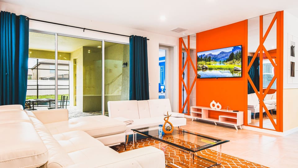 Vibrant living room with bold decor, comfy seating, and poolside patio access.