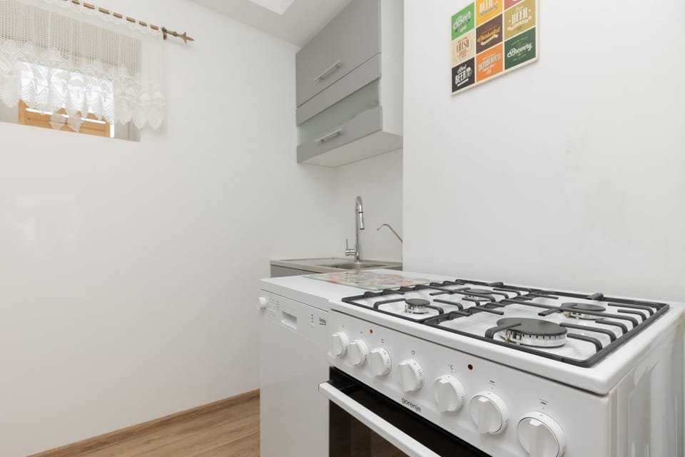 A compact kitchen area with a microwave, cabinets, and a clean, modern design, featuring light tones.