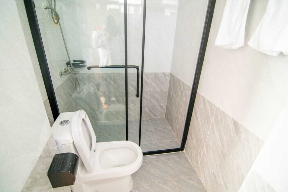 Deluxe Studio | Bathroom | Shower, rainfall showerhead, slippers, towels