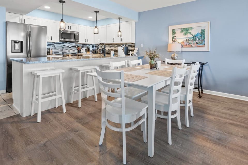 Kitchen island with bar seating opens to the dining table at Beach Club 2 9B, Windy Hill