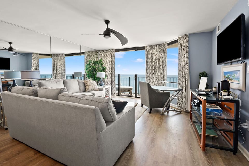 Sectional seating and a work desk face the ocean windows at Beach Club 2 9B in Windy Hill