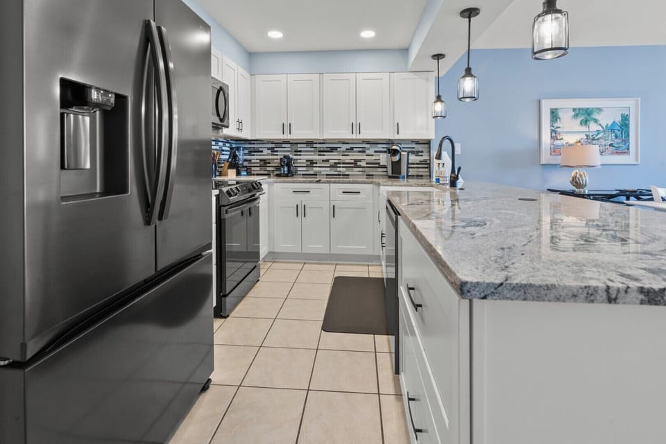 White cabinetry and a full range in the kitchen at Beach Club 2 9B, a 3-bedroom Windy Hill condo