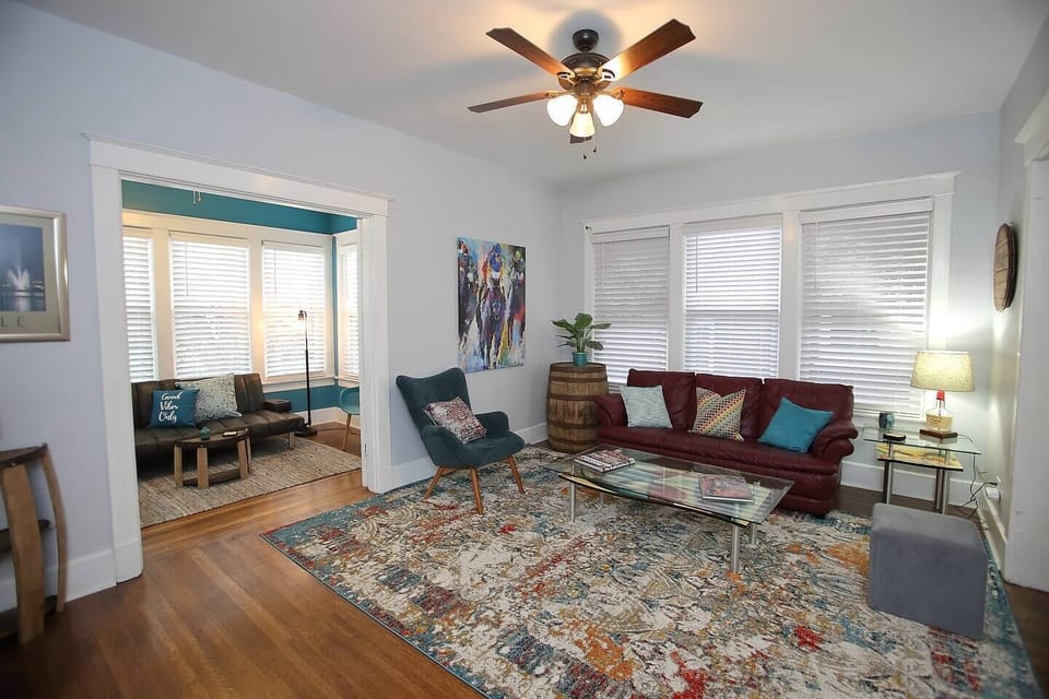 Relax in the spacious living room featuring a pop of red and local art.