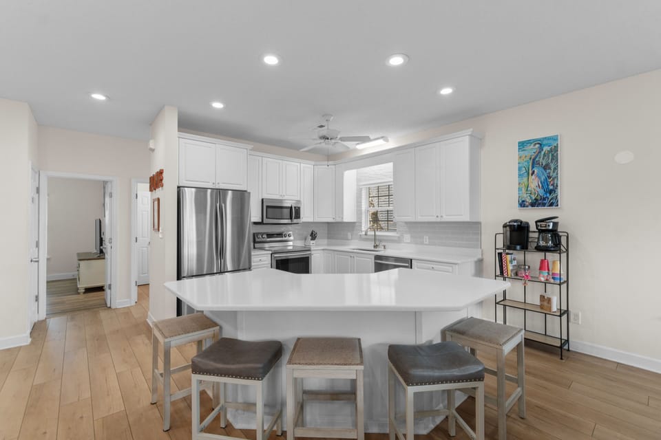 Your modern kitchen features stainless steel appliances, spacious white countertops, and a convenient breakfast island where you can start each morning.