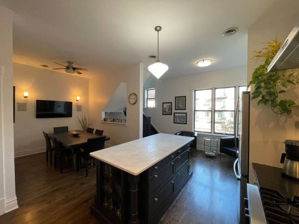 Light & Bright Kitchen with Marble center island and seating by the sunny windows for morning coffee.